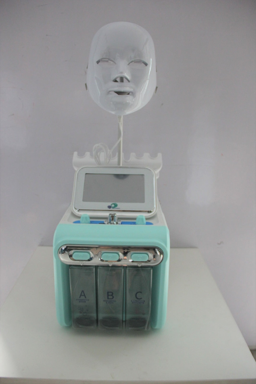 Turquoise electronic device with a face mask on a white background
